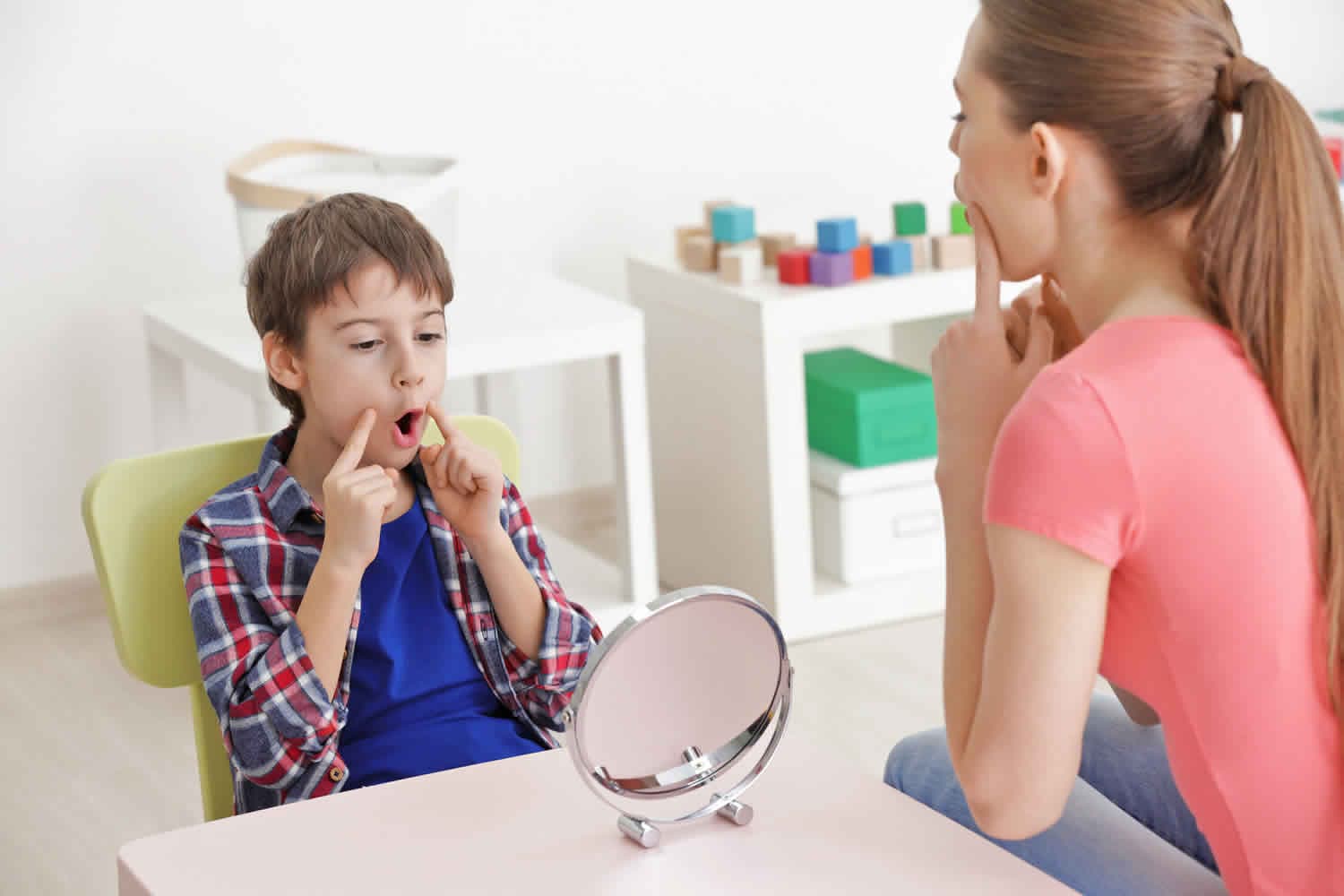 Speech therapist working with a child on articulation
