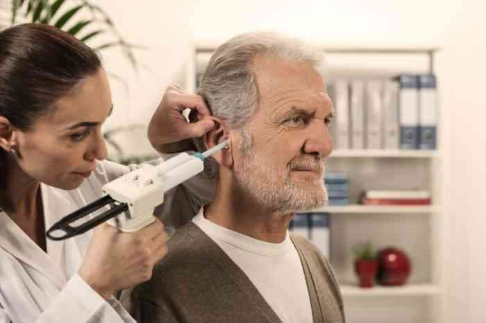 Audiologist performing impedance audiometry test